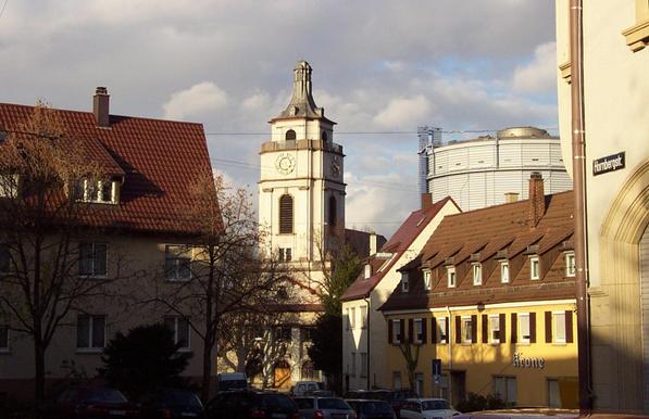 Blick auf einen Teil von Stuttgart-Gaisburg. In Bildmitte der Turm der im späten Jugendstil errichteten Gaisburger Kirche, rechts daneben über Wohnhäusern der Gaskessel.